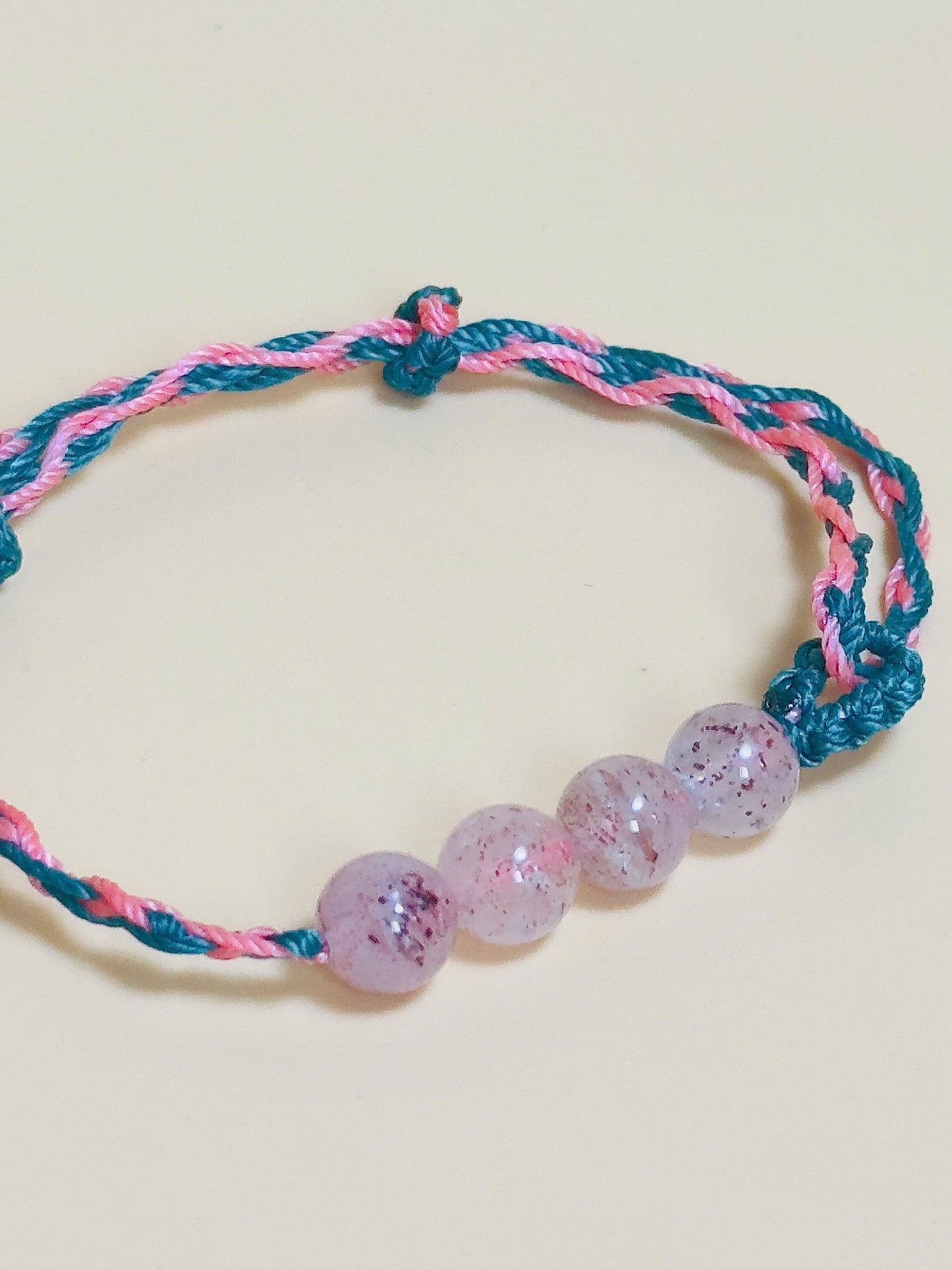 Pink strawberry quartz bracelet with whale tail closure on hand