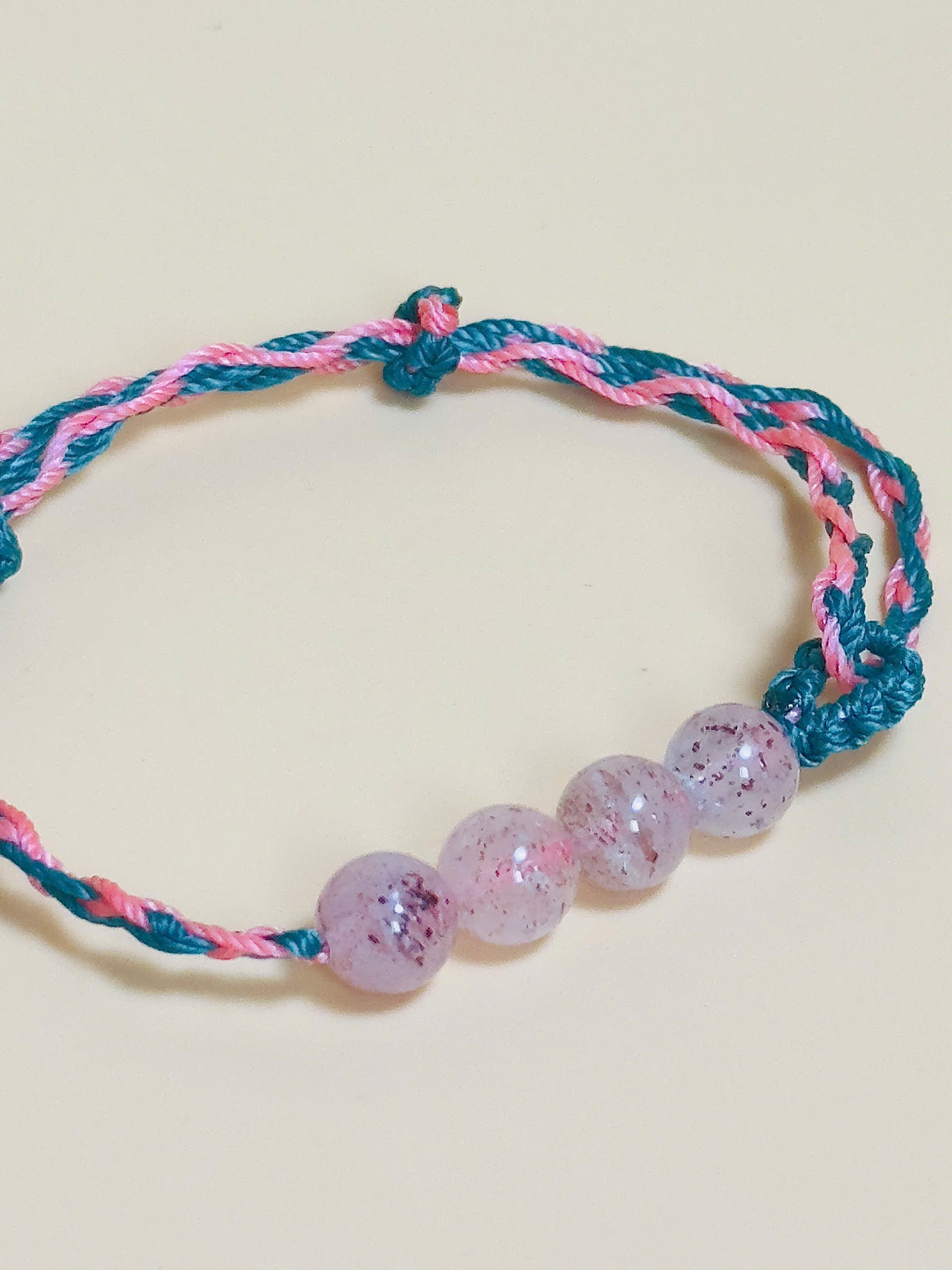 Pink strawberry quartz bracelet with whale tail closure on hand