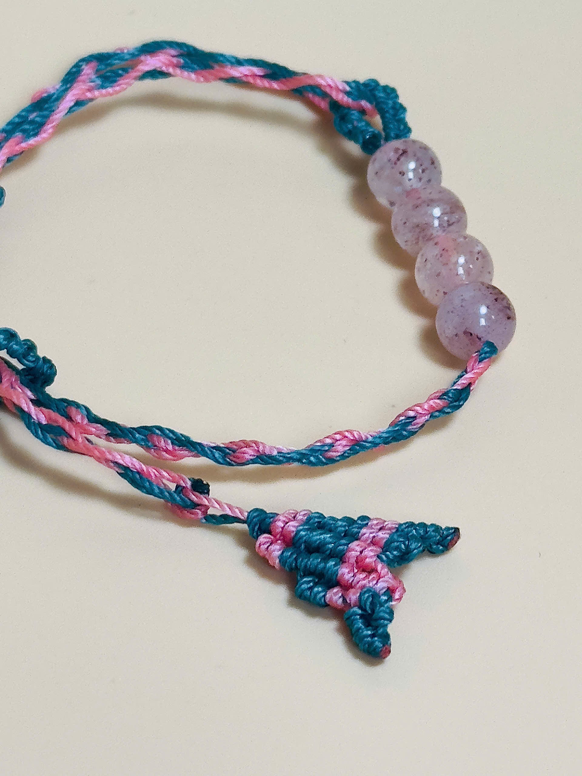 Pink strawberry quartz bracelet with whale tail closure on hand