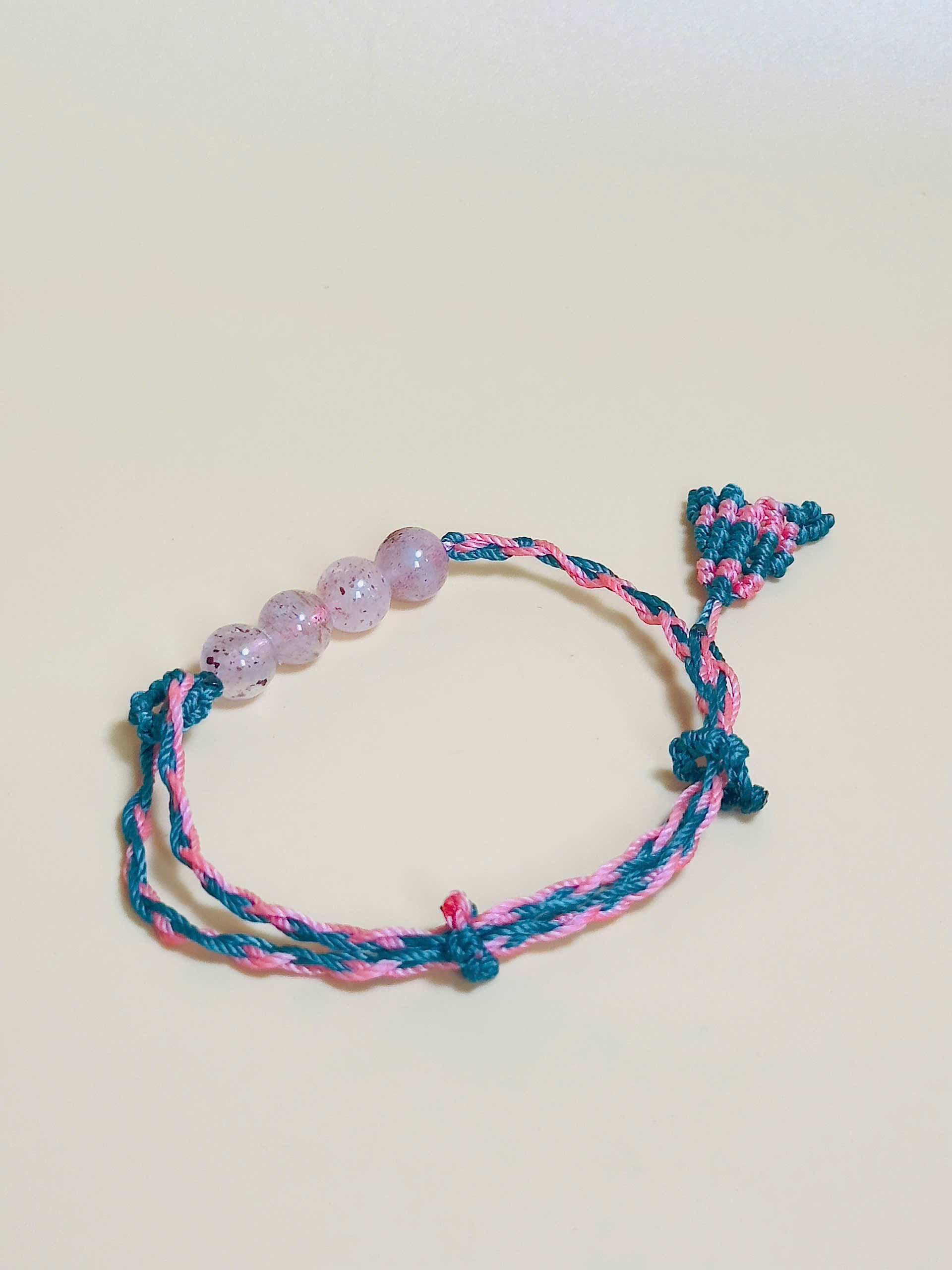 Pink strawberry quartz bracelet with whale tail closure on hand