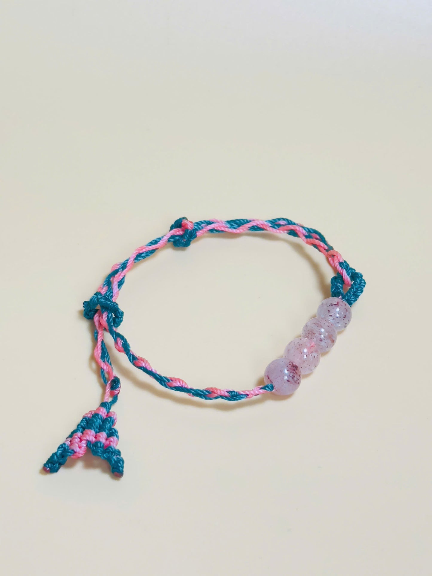 Pink strawberry quartz bracelet with whale tail closure on hand