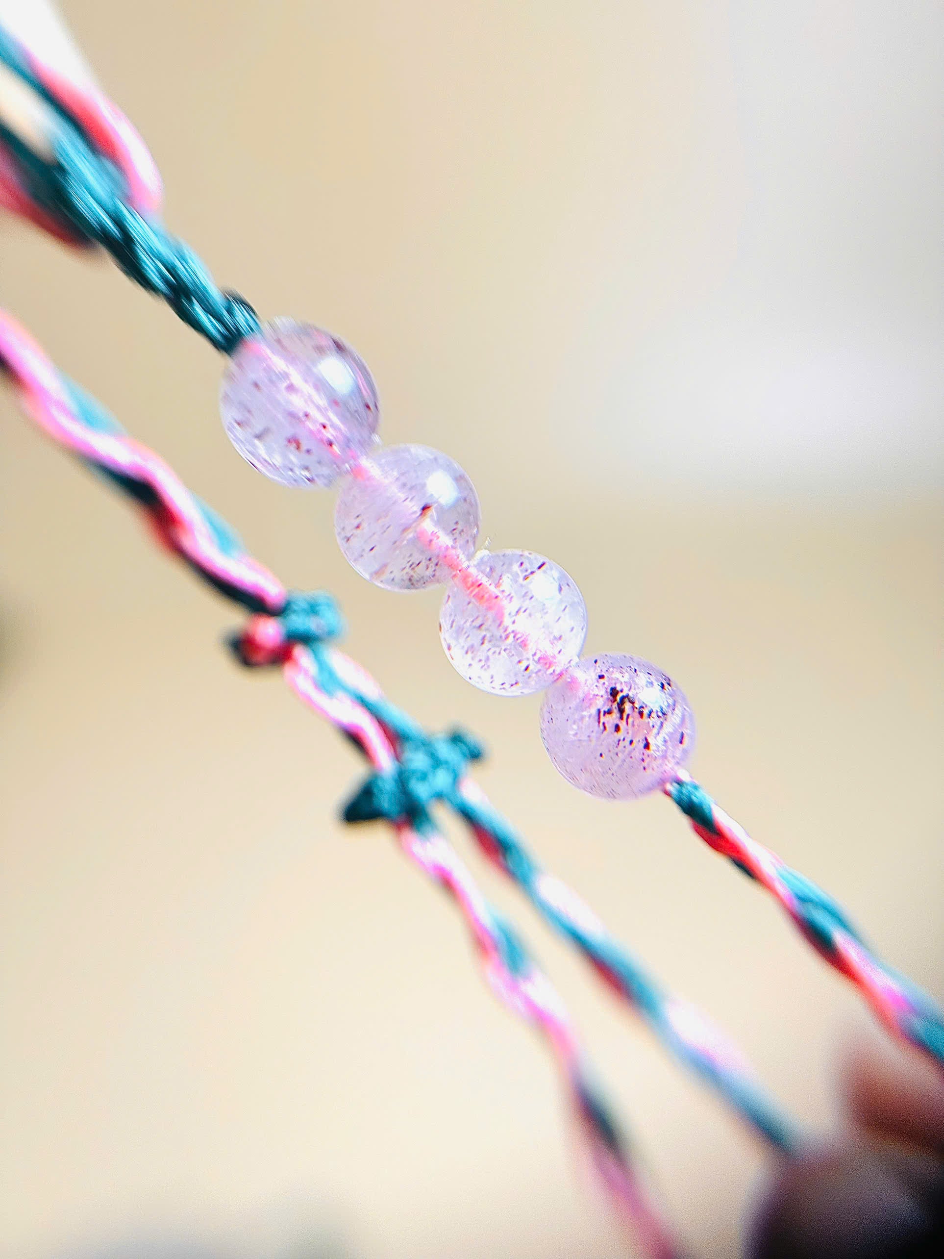 Pink strawberry quartz bracelet with whale tail closure on hand