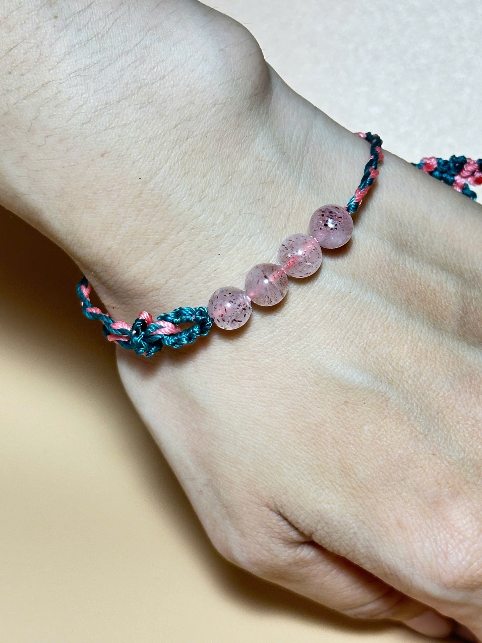 Pink strawberry quartz bracelet with whale tail closure on hand